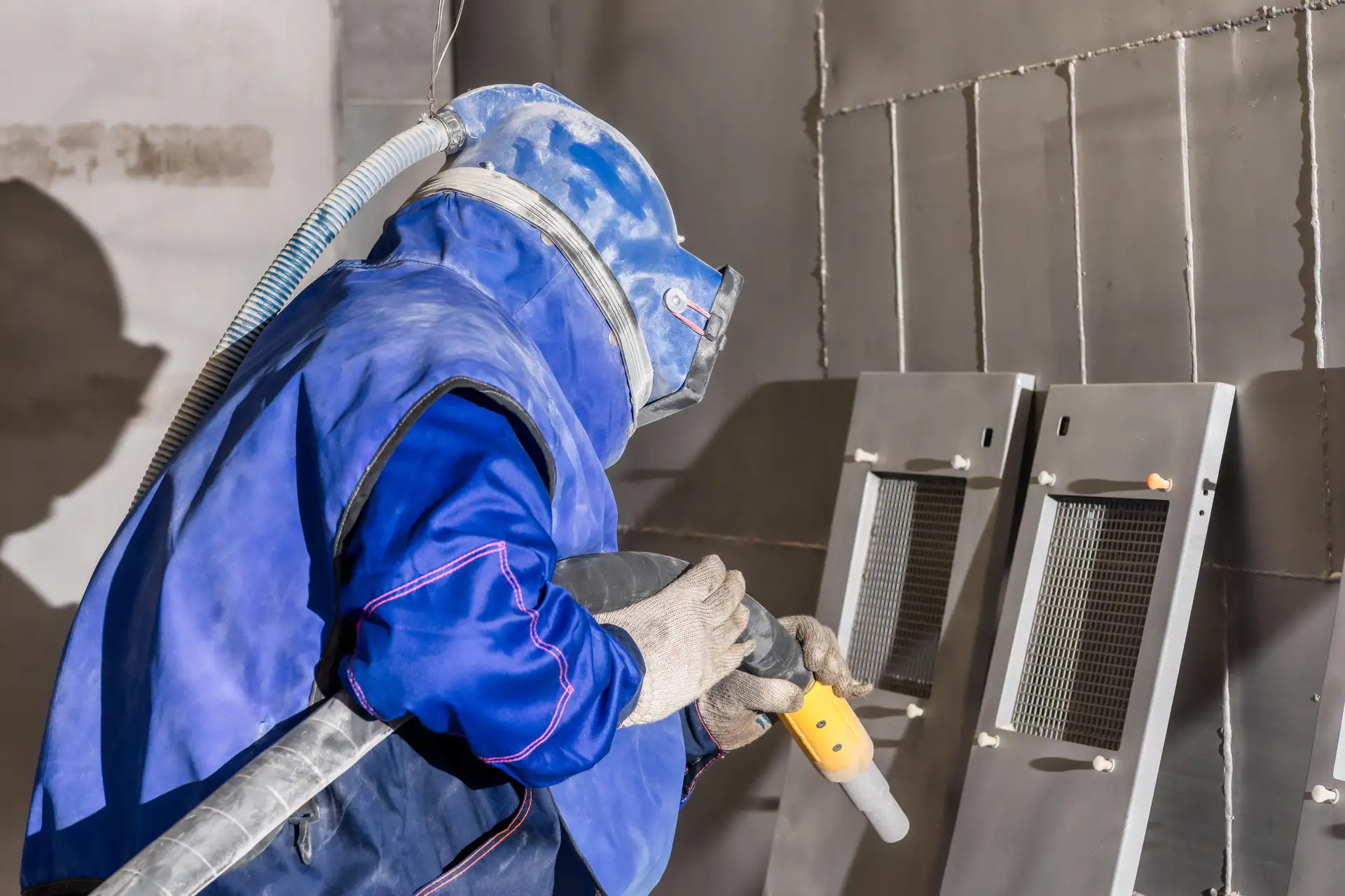 Personne qui décape un objet en métal - Atelier Peinture Augelle